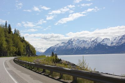 mountains across the water and the highway running along the sea