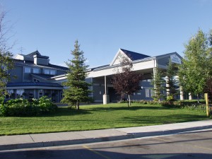 Entrance to the Fairbanks Princess Riverside Lodge with green grass and blue sky in Fairbanks, Alaska - Princess Lodges