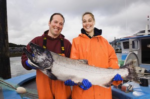 two fisherpeople holding a salmon