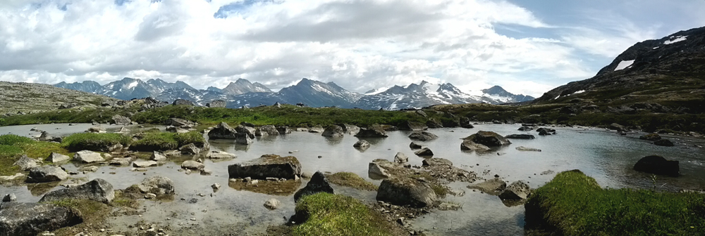 Skagway view of mountains, river and cloud-dotted sky - Princess Lodges