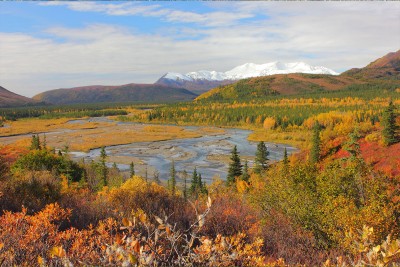 Alaska lake in the fall with brightly colored trees and mountains in the background
