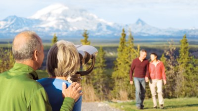 Couple enjoying lookout binoculars at the Copper River Princess Wilderness Lodge