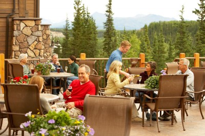 Guests at happy hour on the deck of the Denali Princes Wilderness Lodge