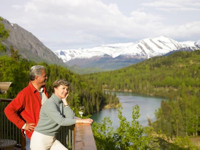 Couple enjoying wine on the Kenai Princess Lodge deck overlooking the river and mountains