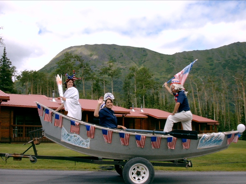 Employees ride in a boat in the parade