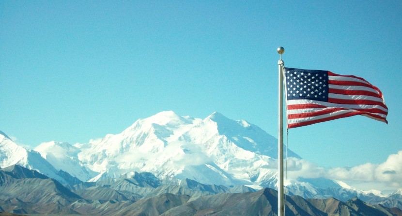 The American flag flies in front of Denali