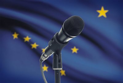 A microphone in front of the Alaska state flag