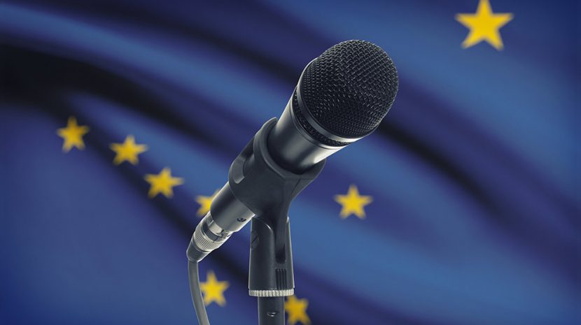A microphone in front of the Alaska state flag