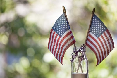 Two small American flags in a decorated mason jar