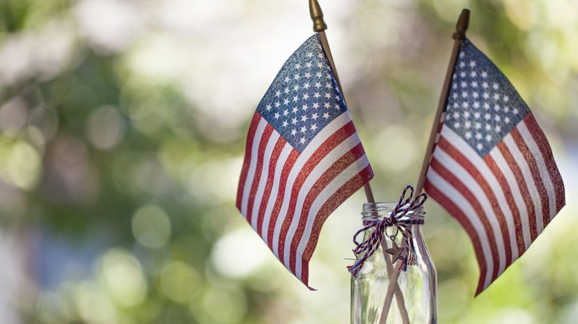 Two small American flags in a decorated mason jar