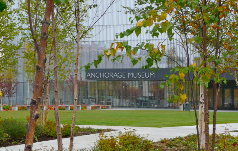 The entrance to the Anchorage Museum shown between aspen trees.