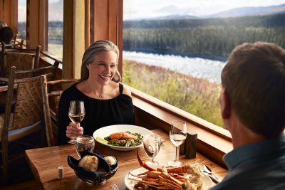 Couple dining at King Salmon Restaurant in Alaska overlooking the Nenana River