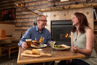 Two diners sharing a laugh and a meal at Trackers Bar & Grill