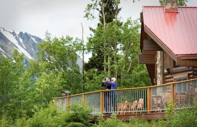 A couple on the deck of Kenai Princess Wilderness Lodge