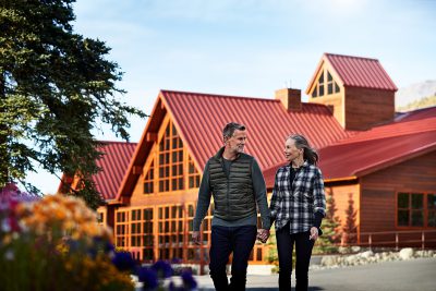 A couple strolls in front of Denali Princess Wilderness Lodge.