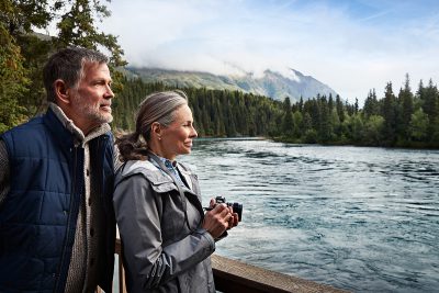 A couple overlooks the river at Kenai Princess Wilderness Lodge