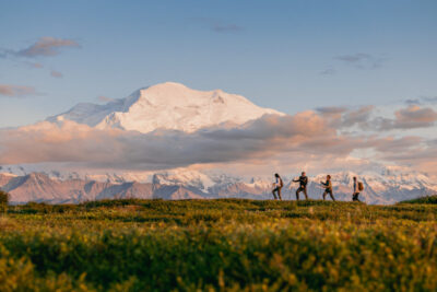 People hiking with view of Denali.